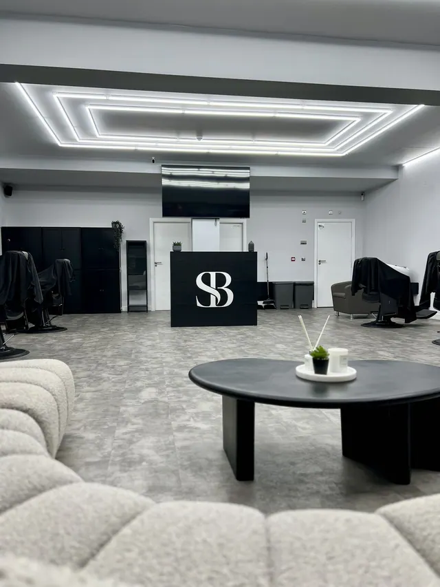 The front desk and barber chairs beyond the lounge