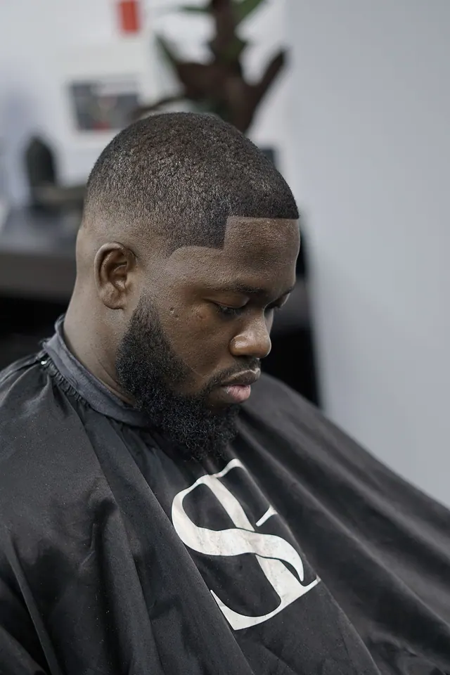 A high skin fade with a full beard