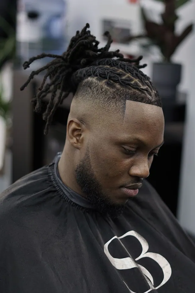 Locs with a skin fade and a sharp line-up